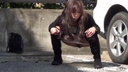 Ponytailed teen girl from Japan in a light raincoat pissing between cars