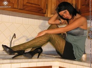 Hot legs and cute feet in pretty green stripped pantyhose served on kitchen counter