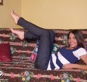 Blue sneaker babe struts her bare feet on the couch.