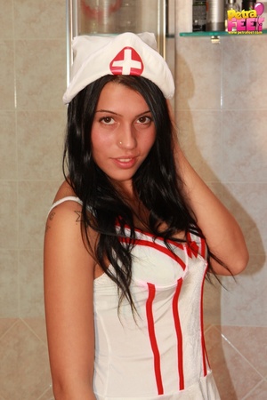 Excellent doe in a nurse costume takes off her white wedges. - Picture 1