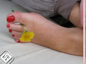 Alluring broad on a white bench showing off her red painted toe nails. - Picture 4