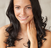 Lovely trick in a grey dress opens her pussy on white sheets.