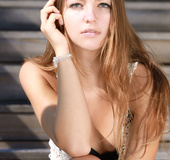 Captivating madam in a black bikini poses nude with some yellow flowers.