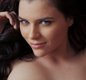 Sumptuous dame in white lingerie opens her legs on a white sofa.