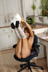 Playful pigtailed teen in glasses and long socks stuffing a lollipop and