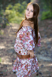 Long-haired ginger beauty with big tits relaxing naked in the forest on her floral blouse