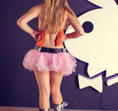 Lovely fair-haired teen in an range top, pink bouffant skirt and bunny