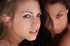 Sizzling sapphic sirens in black heels posing nude at the doorway.