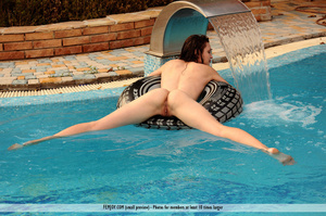 Enticing naked lady poses with an inner tube at the pool. - Picture 14