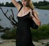 Slim pretty blonde in black dress models tempting flawless nude body by