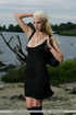 Slim pretty blonde in black dress models tempting flawless nude body by