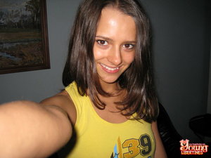 Flirty, slender brunette slides out of yellow tank and blue panties to show off shaved snatch. - Picture 3