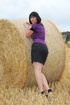 Brunette in a hayfield shimmies out of black skirt to reveal ass in fitted,
