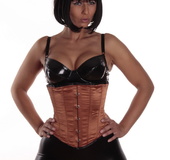 Girl with golden skin and a bob haircut in a sexy corset and tight, shiny