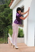 Lady unbuttons purple satin top and reaches into white nylons to pay attention