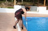 Girl takes off burgundy dress to clean pool in diamond-patterned toe-to-waist