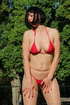 Brunette takes in the sun’s rays in red string bikini and sheer, nude