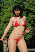 Brunette takes in the sun’s rays in red string bikini and sheer, nude