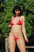 Brunette takes in the sun’s rays in red string bikini and sheer, nude