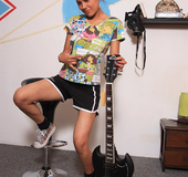 Rock chick in black shorts with a guitar and displays her pussy.