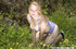 Girl in a bed of grass pleasures herself when nobody is watching.
