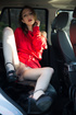 Highly alluring hottie rides on a car in stunning red dress and black