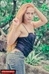 Youthful trannie in a sexy, black camisole and snug jeans seductively