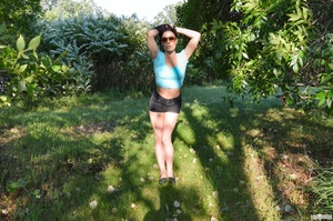 First-rate chica in a blue midriff shirt and black shorts flashing her boobs under a tree. - Picture 2