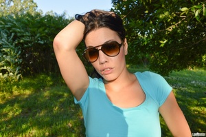 First-rate chica in a blue midriff shirt and black shorts flashing her boobs under a tree. - Picture 9