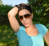 Desirable minx in a blue midriff top and black shorts flashes her boobs