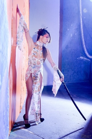 Desirable minx in a sheer sexy dress poses with a Japanese sword. - Picture 1