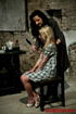 Blonde in a plaid dress gets dolled up and then coffee is poured on her.