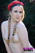 Surrounded by a forest, she poses, dressed as sonya blades from street
