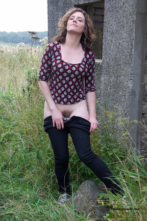 Gorgeous cougar in red and gray polka dotted shirt pulls down her blue jeans and white and black spotted panty and lets you peek at her hairy pussy outdoor. - XXXonXXX - Pic 5