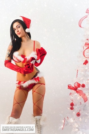 Luscious chick with tattoos displays her smoking hot body wearing her red and white x-mas hat, gloves, stockings and boots before she takes off her red and white lingerie and expose her hot boobs then rubs her pussy by a white x-mas tree. - XXXonXXX - Pic 10