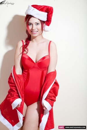 Lovely redhead wearing red santa hat, jacket, nighty and stockings peels them off piece by piece and displays her luscious tits and clean shaved pussy. - Picture 6