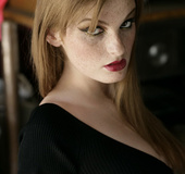 Boobilicious freckled redhead in a black dress smoking and posing