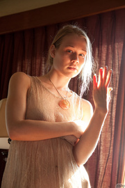 Tender teen doll in a transparent beige dress and nude