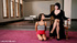 Dominatrix in a black gown totally dominates her sub in a sparsely furnished