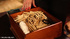 Naked brunette on a black table gets pinched with several clothespins.