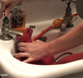 Naked girl cleaning up her ass with a douche system in the bathroom.