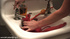 Naked girl cleaning up her ass with a douche system in the bathroom.