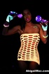 Siren in a mesh tube dress plays with toys under black light.
