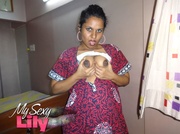 Foxy Indian babe posing in her pink, blue and white dress before she opens it and expose her alluring boobs with big nipples under her white bra.