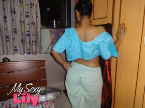 Luscious Indian hottie displays her chubby body before she opens her hanging blue blouse and reveals her big soft breasts then pulls down her white skirt and expose her huge juicy butt in her bedroom. - Picture 9