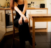 Brunette vixen undresses her dress to pose in stockings topless