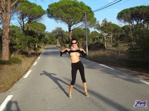 Delightful bitch in a black top and leggings parts her labia on the street. - Picture 6