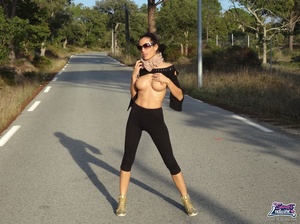 Delightful bitch in a black top and leggings parts her labia on the street. - Picture 9