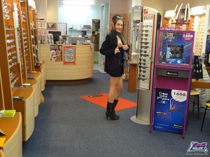 Pretty trick in a black dress and coat flashes at an optical shop. - Picture 5