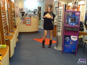 Pretty trick in a black dress and coat flashes at an optical shop. - Picture 7